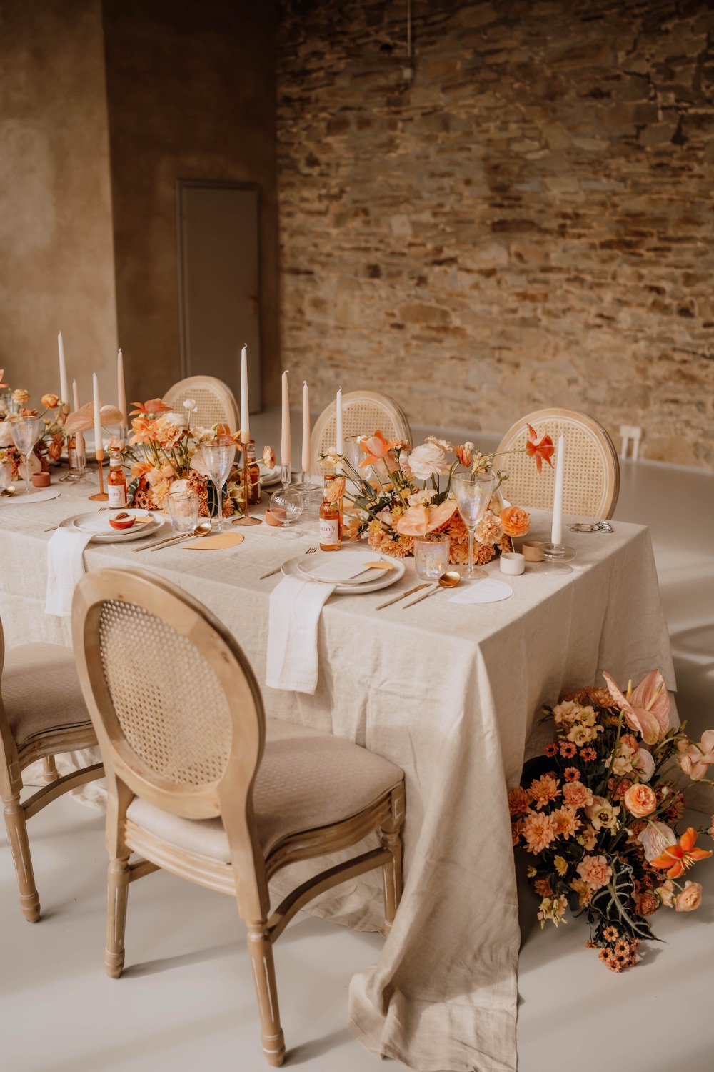 Vollständig eingedeckte Tafel mit Kerzen, Blumenarrangements und eleganten Stühlen im Festplatz Showroom